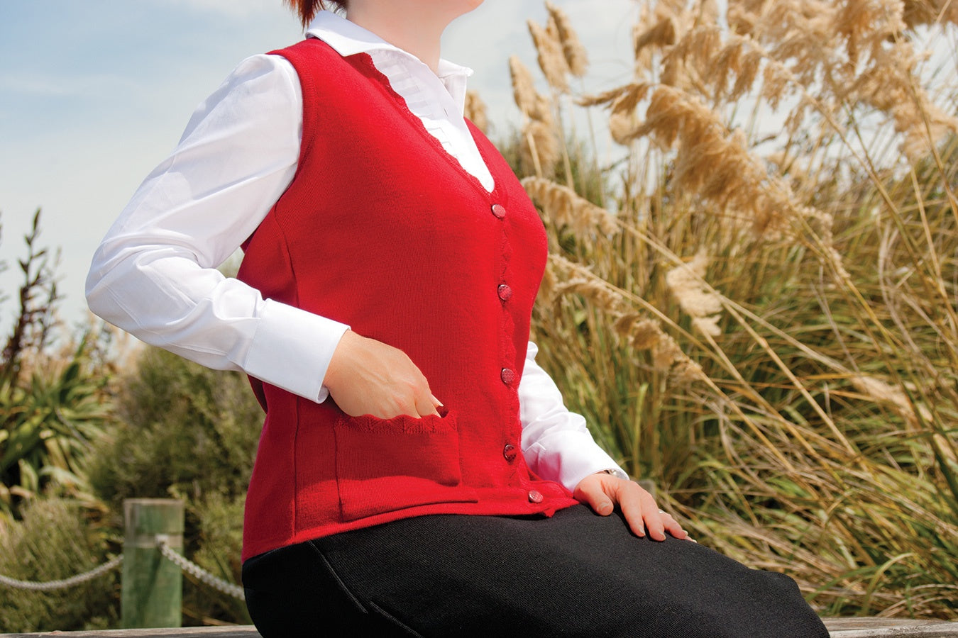 Red Gorgeous 100% Merino AOK Clothing Sleeveless Cardigan. The perfect cardi to take you from Summer to Autumn. The lace trim V neck button vest is fabulous for wearing over blouses and it also features two handy pockets at the front.